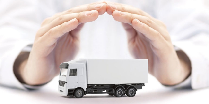 business person's hands protecting a miniature freight vehicle